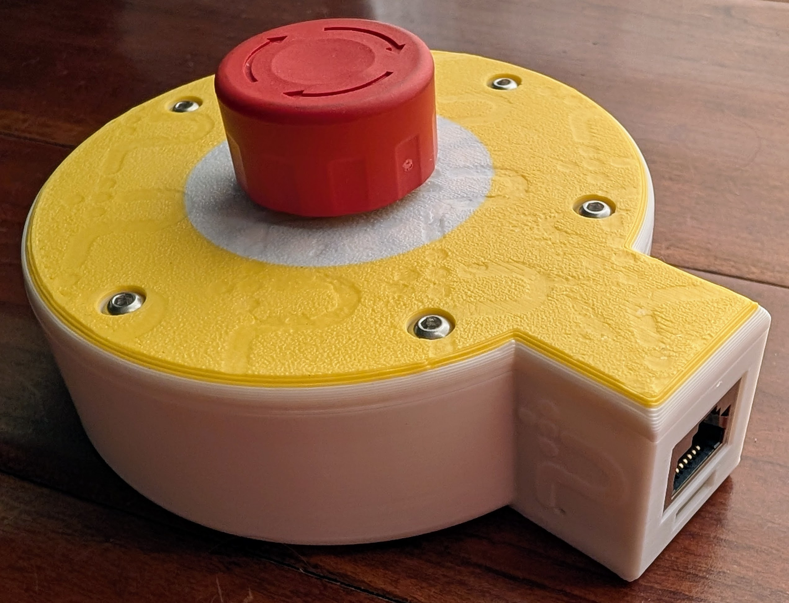 Assembled Protective Stop remote with a red stop button, printed enclosure, and Ethernet side pod
